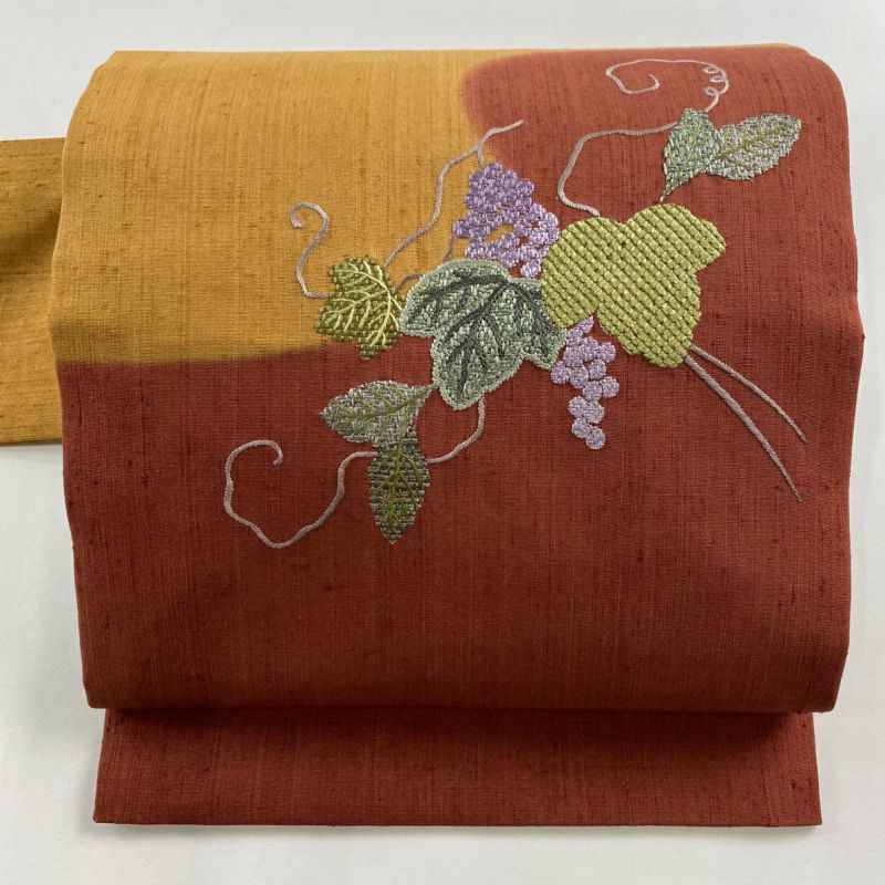 名古屋帯 美品 秀品 紬地 関西仕立て 葡萄 霞 刺繍 えんじ色